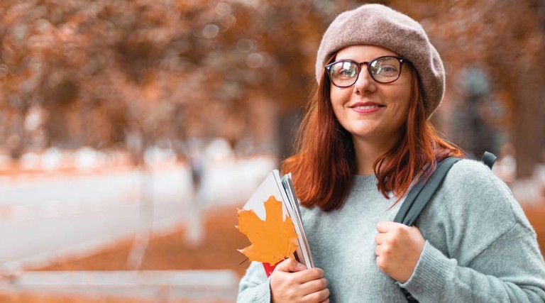 A young woman on a college campus in fall