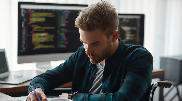 Man working with data on desktop and laptop computers