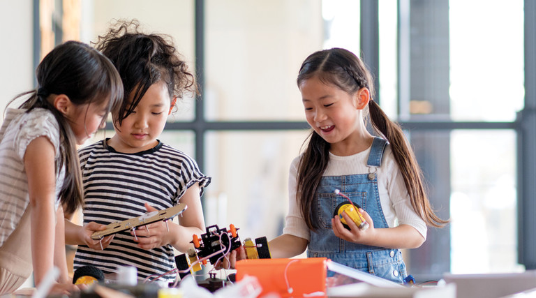 three k-12 students working together on a robotics project